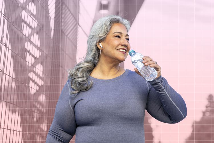 Mujeres mayores que beben agua mientras caminan al aire libre