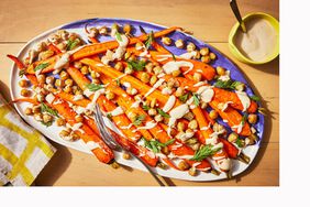 Garbanzo frijoles y zanahorias con sabor a tahini, platos de lino y horquilla de servicio