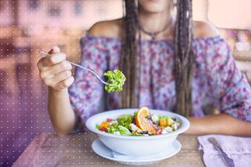 mujer comiendo ensalada en un restaurante