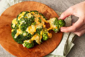 Una receta de brócoli con queso cheddar en una bandeja y una foto de quien lo sostiene.