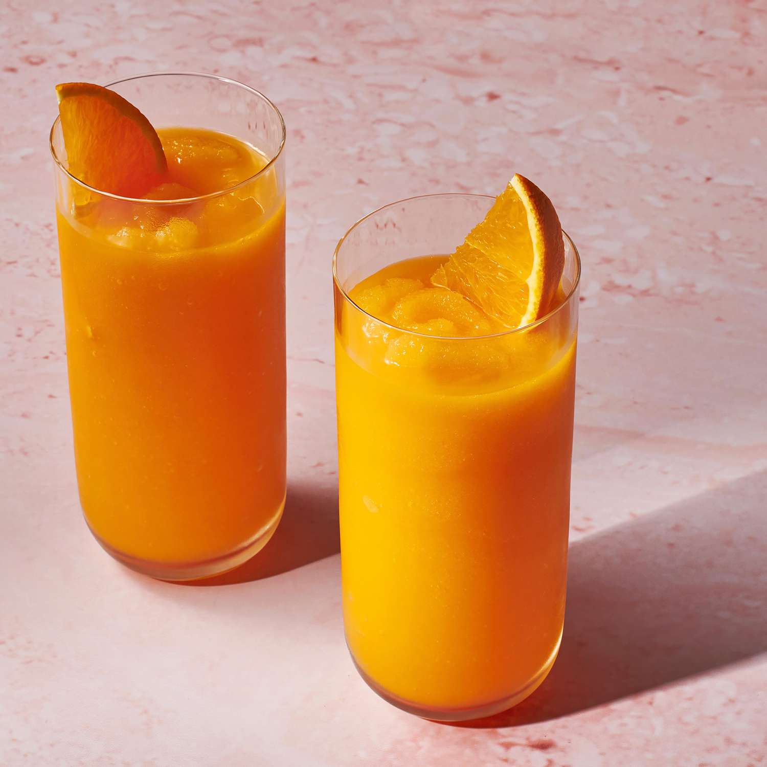 Foto de la receta de batido de zanahoria en dos vasos con rodajas de naranja