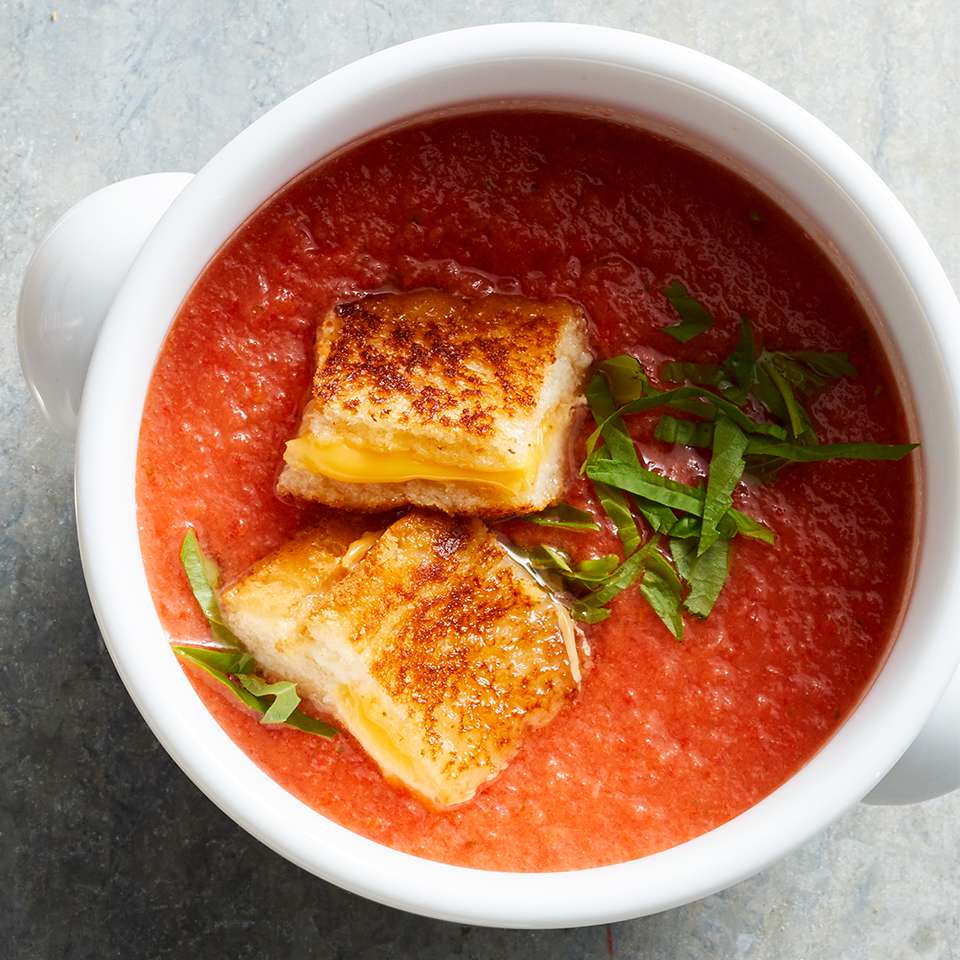 Sirva crutones de queso asados ​​sobre sopa de tomate.