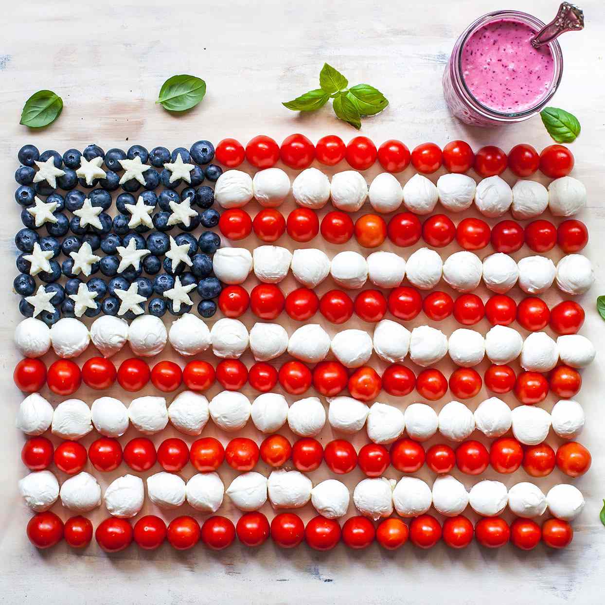 Toma exagerada de la bandera estadounidense con tomates cherry, bolas de mozzarella y arándanos.