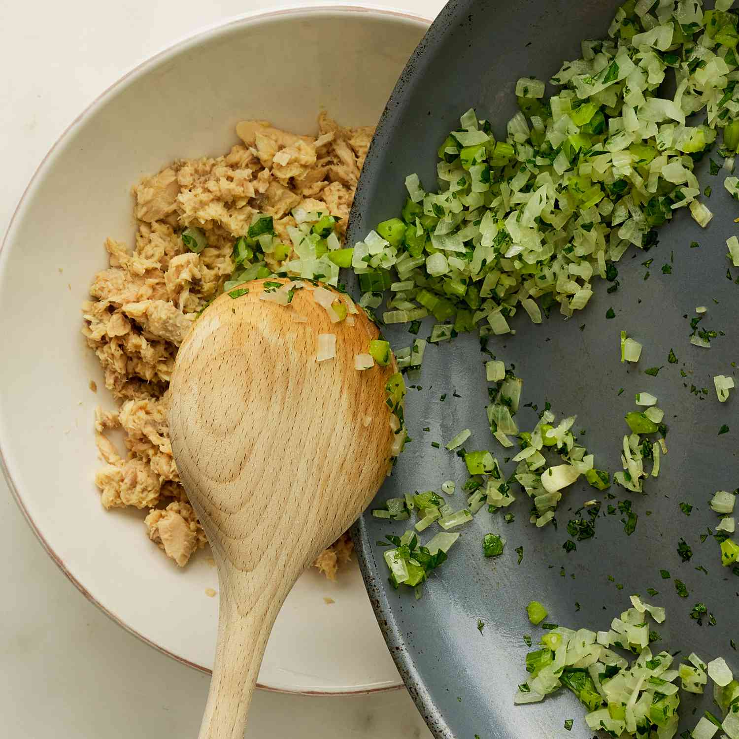 Coloque las verduras fritas en un tazón de salmón con una cuchara de madera.