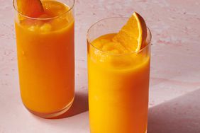 Foto de receta de batido de zanahoria proporcionada con dos vasos decorados con rodajas de naranja