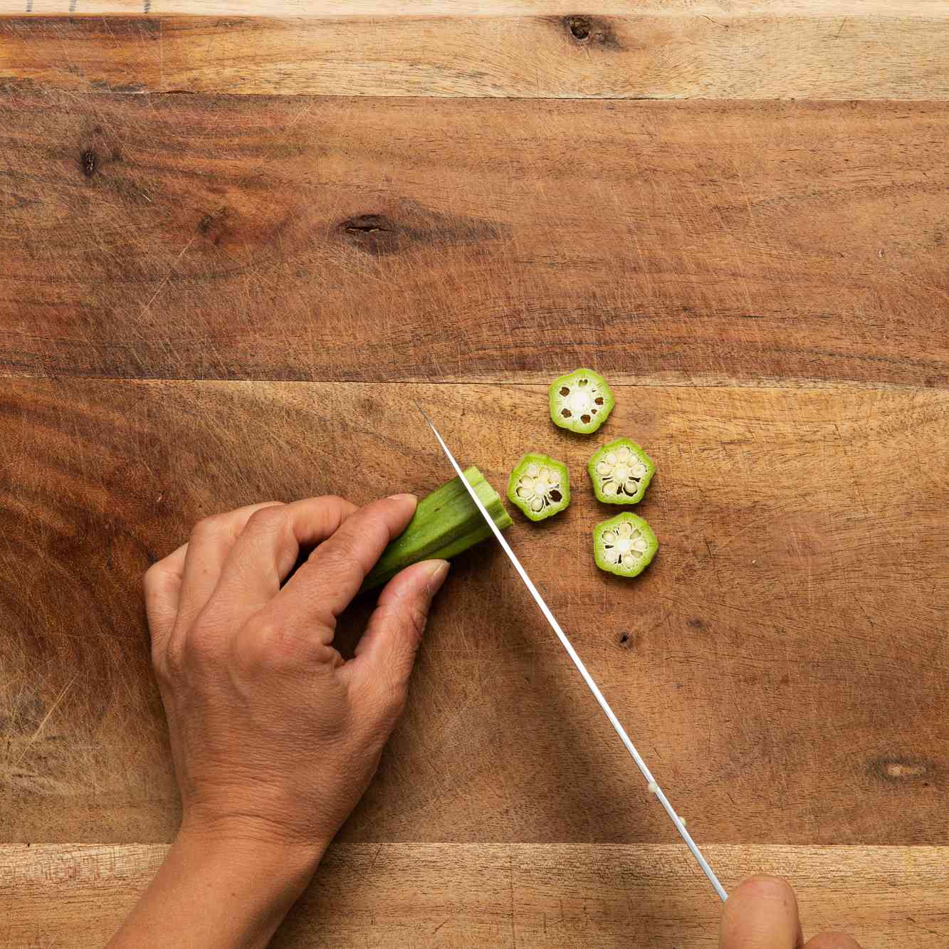 foto de una persona cortando okra
