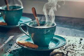 Foto de té caliente en una taza y galletas debajo