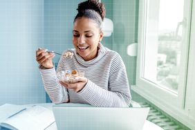 Foto de una mujer desayunando avena en su escritorio una noche