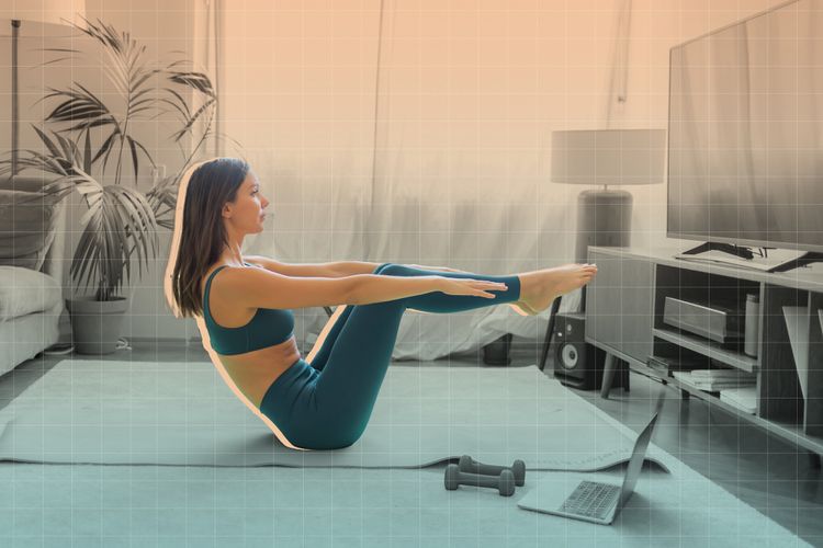 Foto de una mujer haciendo ejercicio sobre una estera de yoga frente al televisor en su sala de estar