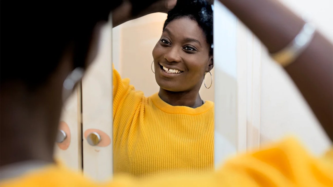 Mirando en el espejo mujeres afroamericanas & amp; lt; lt; pan & amp; gt; después de una dieta poco saludable, un rastro nutriente es deficiente y no come una dieta suficiente, causa una piel seca o empeora. Sí (22, 23).