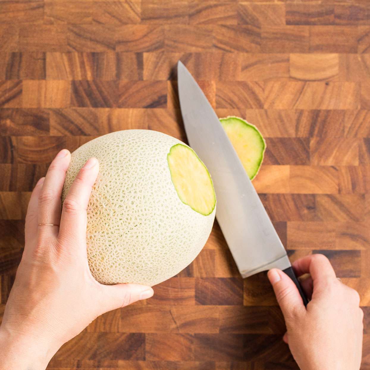 Cuchillo que corta la parte superior del melón en un tablero de madera