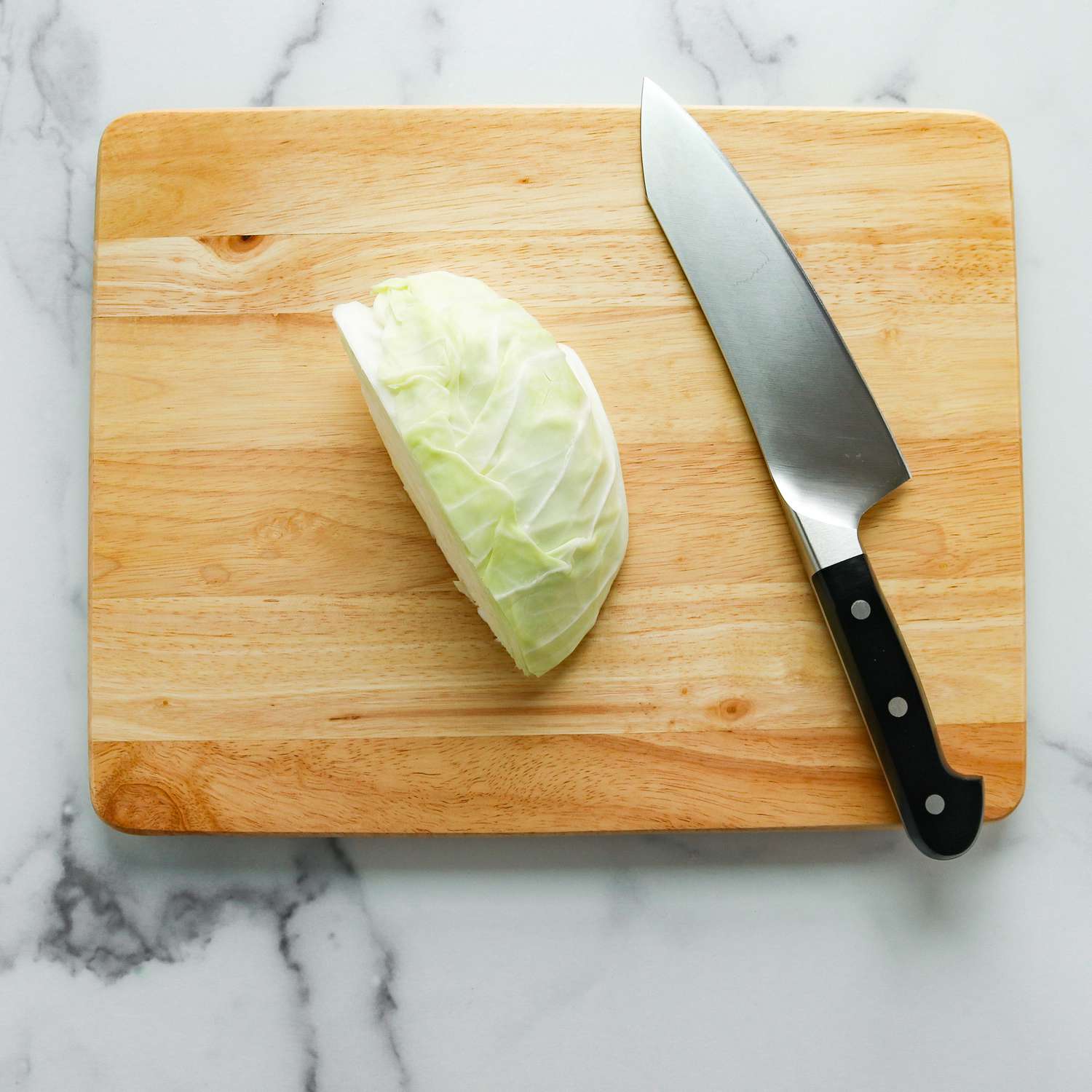 Repollo colocado al lado del cuchillo de cocina en una tabla de cortar