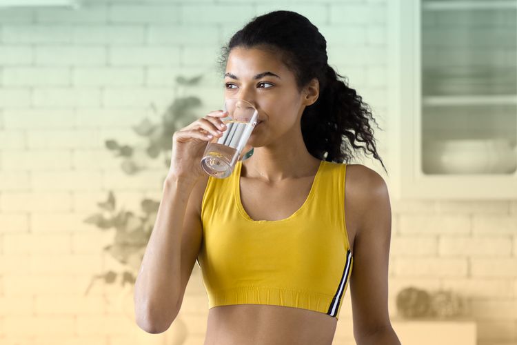 Mujer bebe agua después del ejercicio