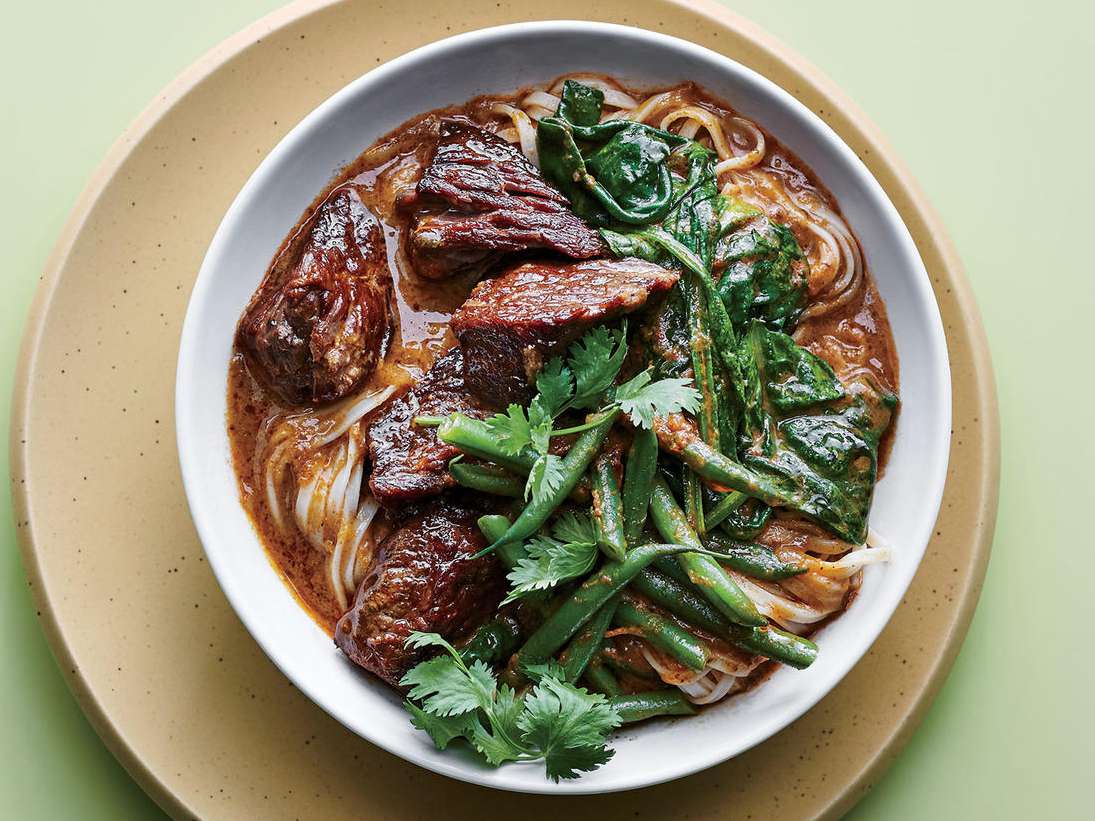 Sirva una carne tailandesa en un tazón con una olla de cocción lenta