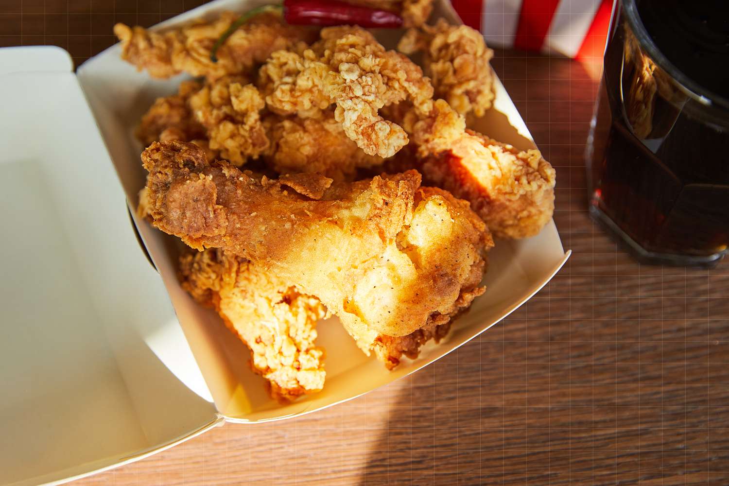 El pollo frito sobre la mesa y los refrescos
