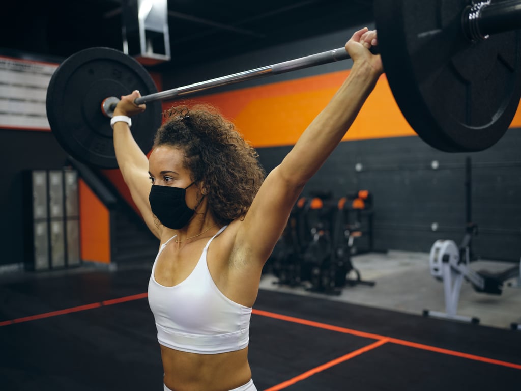 Las mujeres que hacen ejercicio en el gimnasio realizan entrenamiento con pesas con barra.