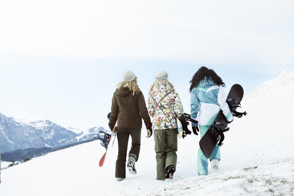 Tres mujeres jóvenes con tablas de snowboard (atrás),