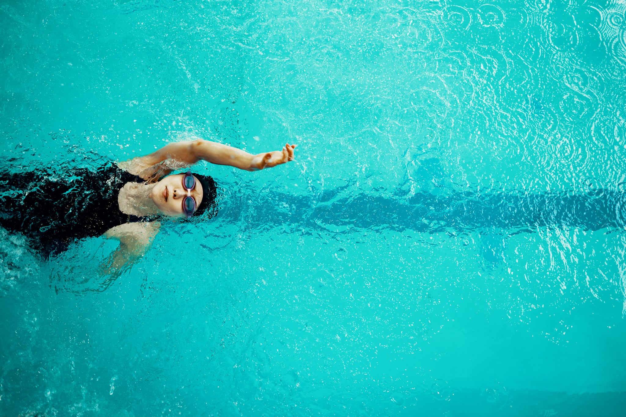 Directamente encima de la vista de una mujer parapléjica entrenando en una piscina para natación competitiva.